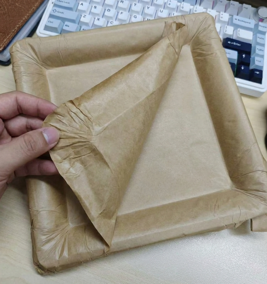 A hand peeling the top layer of a multi-layered paper plate to reveal a clean surface underneath